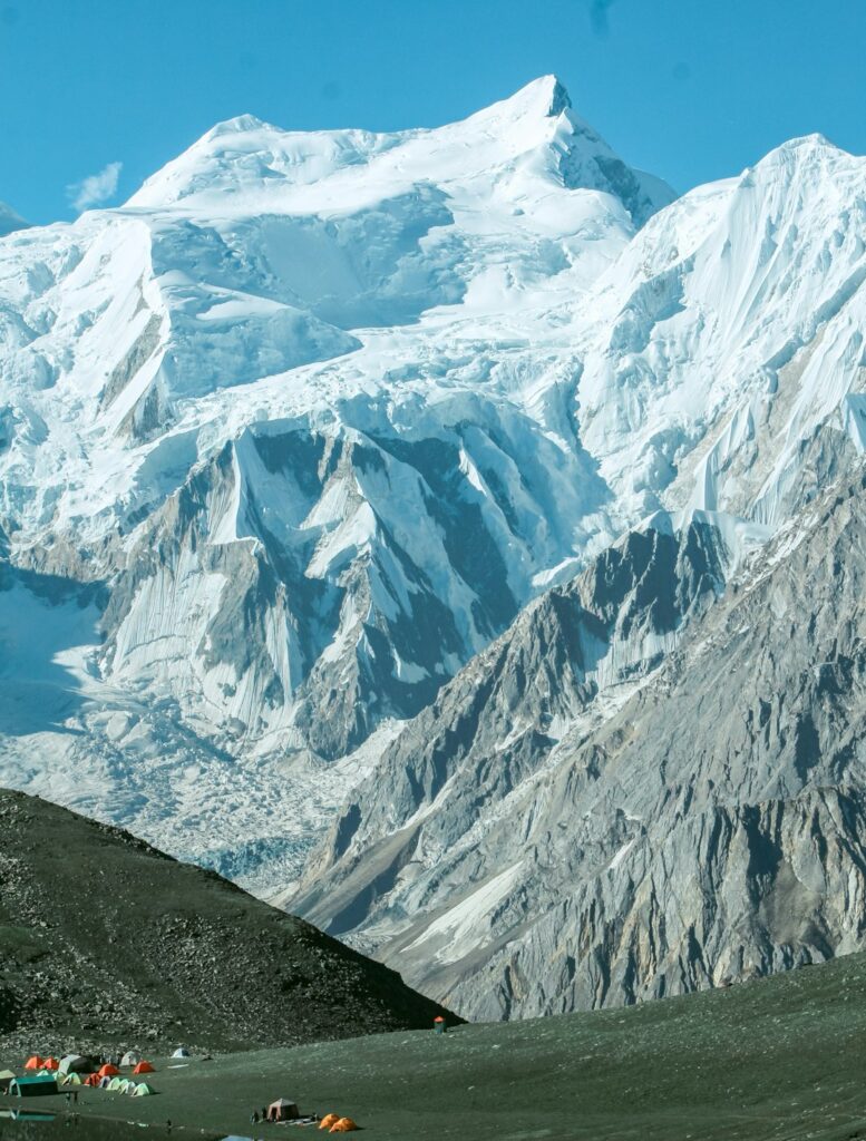 High-altitude expedition camp beneath a snowy Karakoram peak